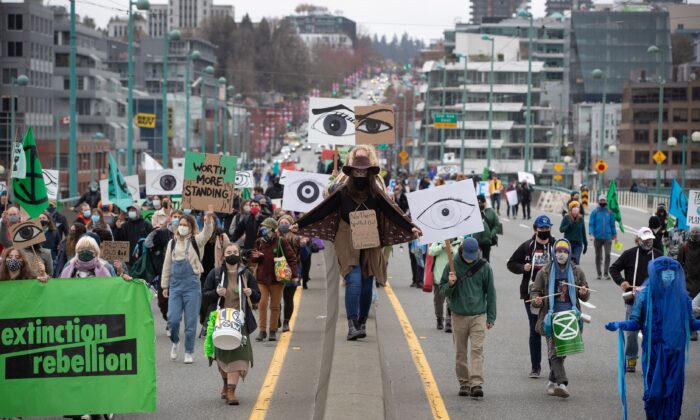 People taking part in a protest against old-growth logging march along Cambie Street Bridge in Vancouver on March 27, 2021. (The Canadian Press/Darryl Dyck)