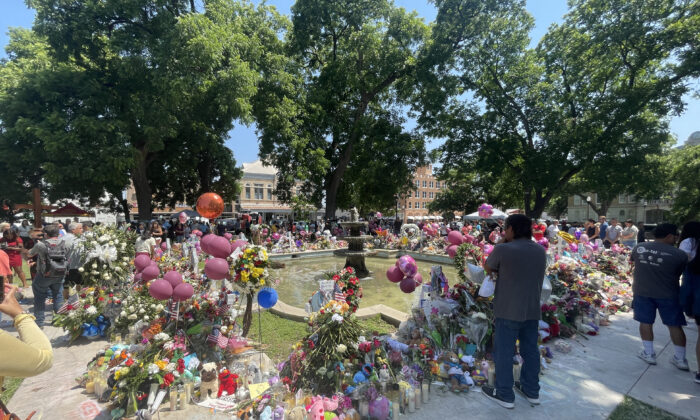 People visit a makeshift memorial for the 21 victims of an elementary school mass shooting in the town square in Uvalde, Texas, on May 29, 2022. (Charlotte Cuthbertson/The Epoch Times)