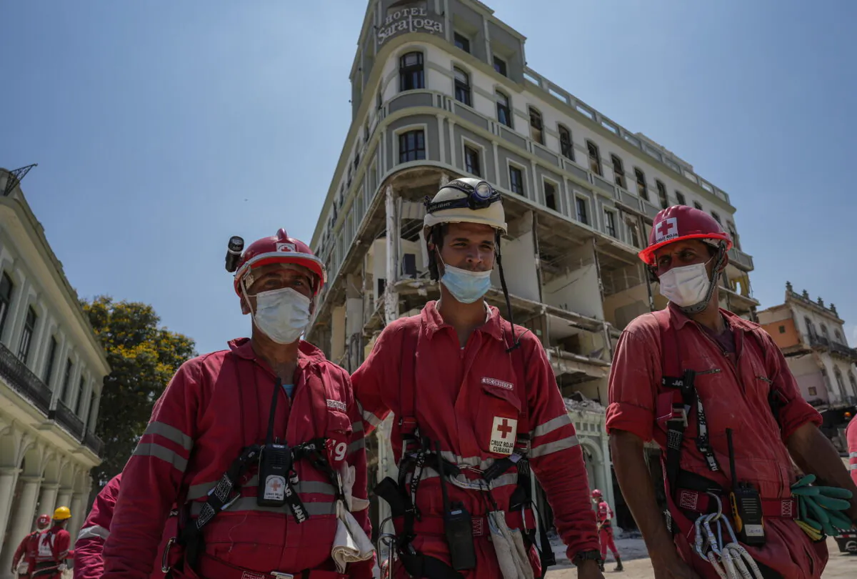 Cuban Red Cross workers walk away from the destroyed five-star Hotel Saratoga after searching through the rubble days after a deadly explosion in Old Havana, Cuba, on May 10, 2022. (Ramon Espinosa/AP Photo)
