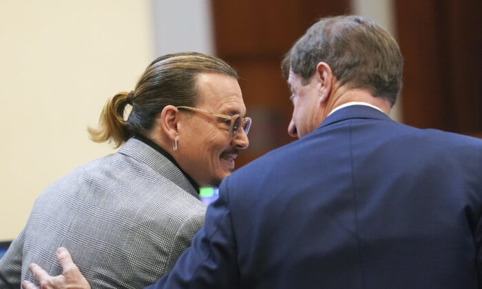 Actor Johnny Depp speaks with his legal team in the courtroom at the Fairfax County Circuit Courthouse in Fairfax, Va., on May 19, 2022. (Shawn Thew/Pool photo via AP)