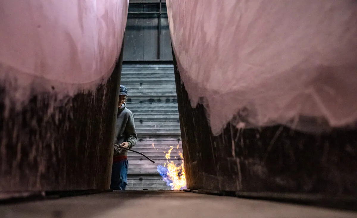 A worker uses a gas burner to prepare a casting mold at a foundry in Krefeld, Germany, on April 21, 2022. (Sascha Schuermann/Getty Images)