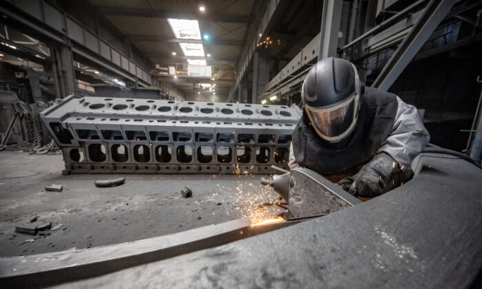 A worker deburrs a casting at the Siempelkamp Giesserei foundry in Krefeld, Germany, on April 21, 2022. (Sascha Schuermann/Getty Images)