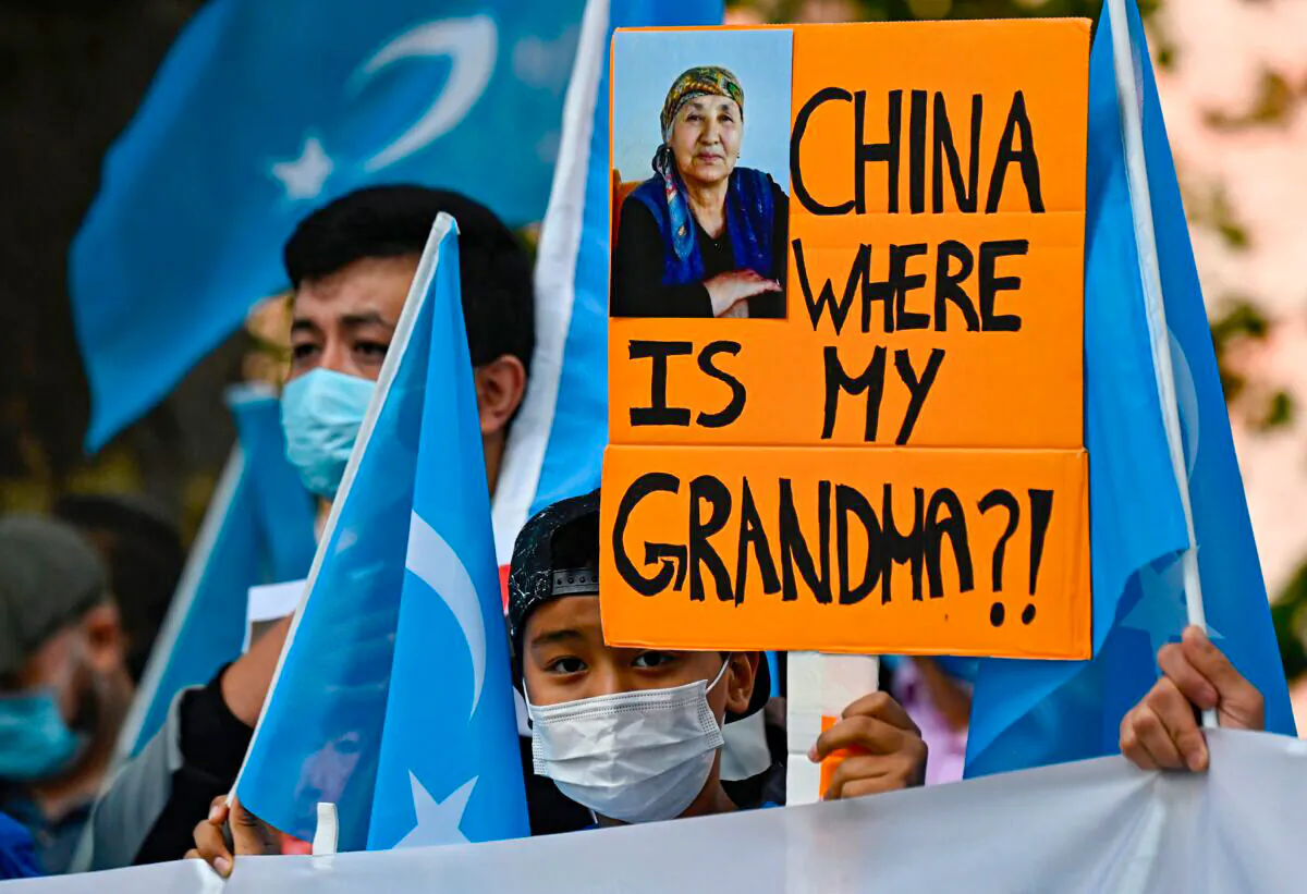 A young Uyghur activist holds up a poster that reads "China where is my grandma?!" during a demonstration outside the Foreign Office in Berlin, where the Chinese Foreign Minister was expected to hold talks with his German counterpart on Sept. 1, 2020. (Tobias Schwarz/AFP via Getty Images)