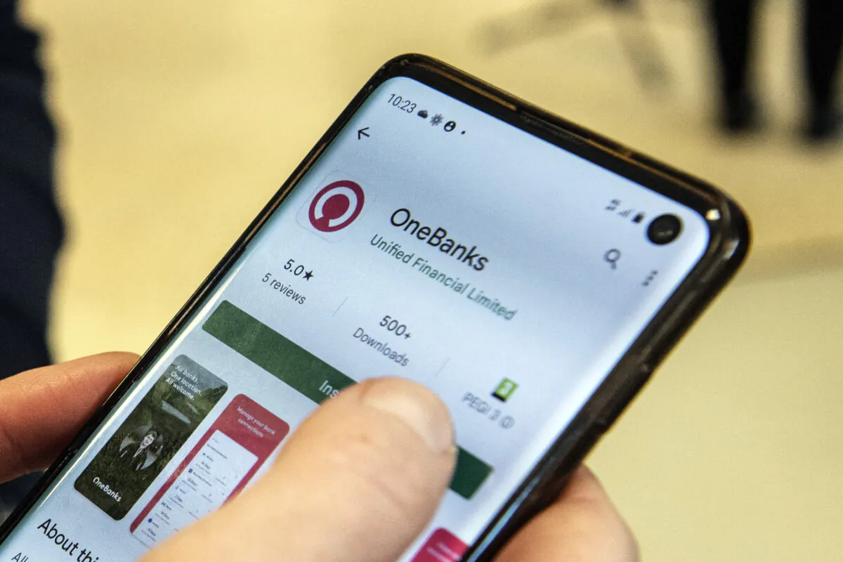 A customer uses the One Banks app on her mobile phone in Denny, Scotland on March 25, 2022. (ANDY BUCHANAN/AFP via Getty Images)