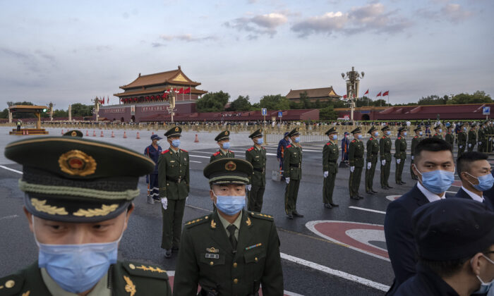 Police officers and security perform crowd control after an official flag raising ceremony to mark National Day next to Tiananmen Square and the Forbidden City in Beijing, China on Oct. 1, 2021. (Kevin Frayer/Getty Images)