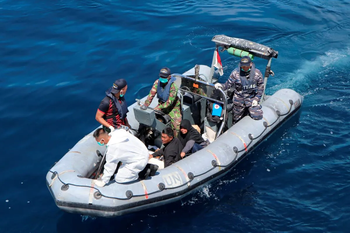Survivors ride on an Indonesian Navy boat after being retrieved from the water during the rescue operation for the victims of a sinking cargo boat in the Makassar Strait, Indonesia, on May 29, 2022. (BASARNAS via AP)