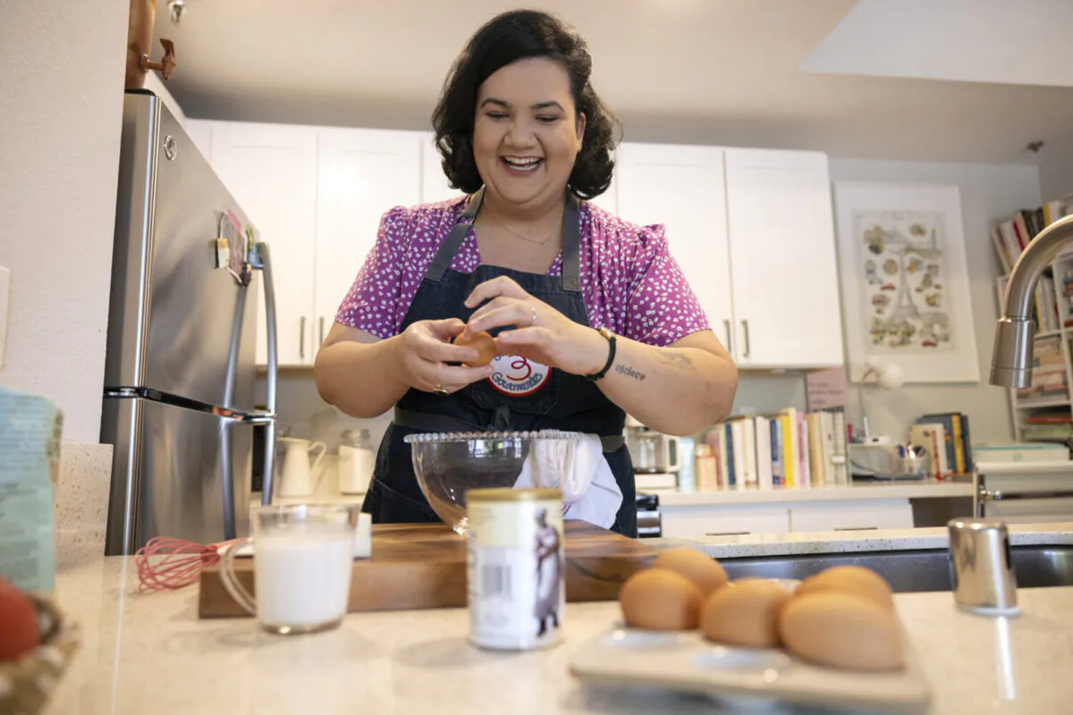 Oceanside resident Jaine Mackievicz-Cenci, who grew up in Brazil watching Julia Child's cooking show on TV, breaks eggs while making an olive oil and vanilla cake in her apartment in Oceanside on Wednesday, May 18, 2022. (Hayne Palmour IV/San Diego Union-Tribune/TNS)
