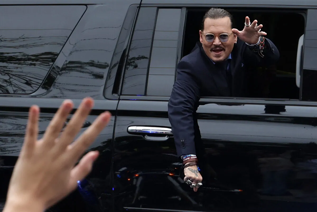 Actor Johnny Depp waves to supporters from his vehicle as he leaves a Fairfax County Courthouse in Fairfax, Va., on May 27, 2022. (Alex Wong/Getty Images)