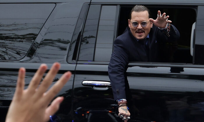 Actor Johnny Depp waves to supporters from his vehicle as he leaves a Fairfax County Courthouse in Fairfax, Va., on May 27, 2022. (Alex Wong/Getty Images)