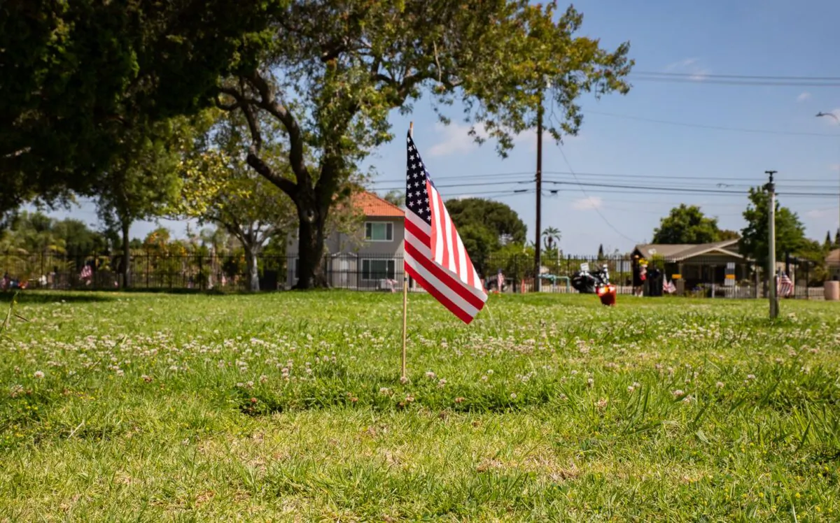 A flag is placed over the grave of a veteran as people partake in the annual Memorial Day Service at Fairhaven Memorial Park in Santa Ana, Calif., on May 30, 2022. (John Fredricks/The Epoch Times)