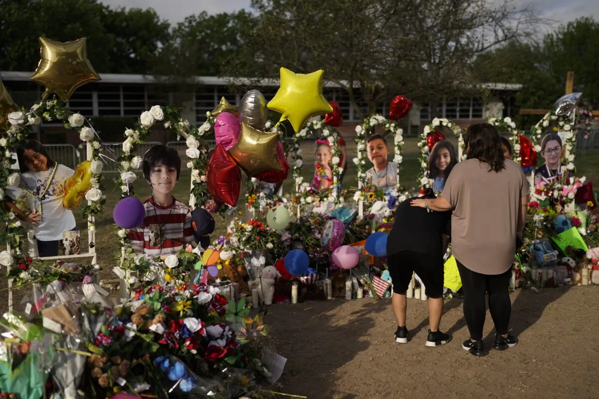 Jolean Olvedo (L) weeps while being comforted by her partner Natalia Gutierrez at a memorial for Robb Elementary School students and teachers who were killed in last week's school shooting in Uvalde, Texas, on May 31, 2022. (Jae C. Hong/AP Photo)