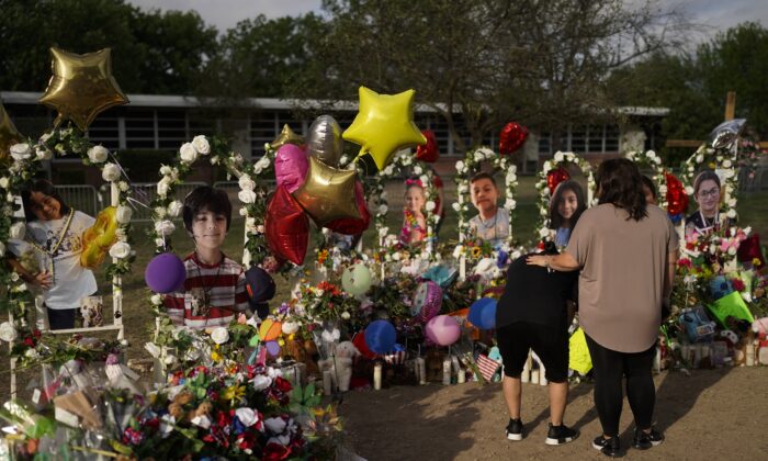 Jolean Olvedo (L) weeps while being comforted by her partner Natalia Gutierrez at a memorial for Robb Elementary School students and teachers who were killed in last week's school shooting in Uvalde, Texas, on May 31, 2022. (Jae C. Hong/AP Photo)