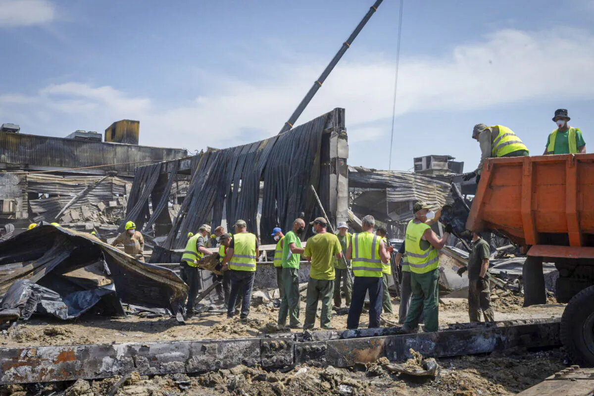 Workers clear debris at a shopping center that was damaged in a Russian rocket attack in Kremenchuk, Ukraine, on June 29, 2022. (Efrem Lukatsky/AP Photo)