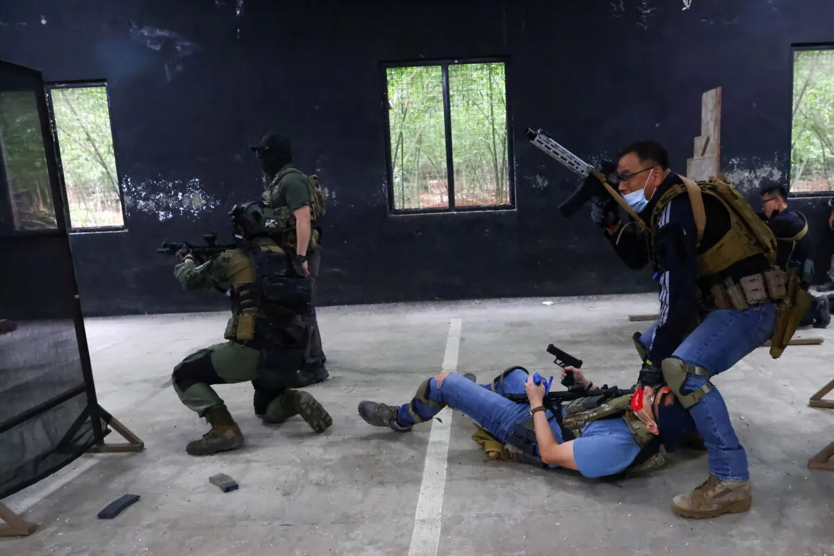 Trainees work on a simulated hostage rescue mission during an airsoft gun training lesson at the shooting range of the combat skill training company Polar Light, in New Taipei City, Taiwan, on May 22, 2022. (Ann Wang/Reuters)