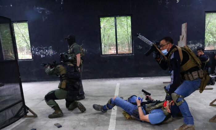 Trainees work on a simulated hostage rescue mission during an airsoft gun training lesson at the shooting range of the combat skill training company Polar Light, in New Taipei City,  Taiwan, on May 22, 2022. (Ann Wang/Reuters)