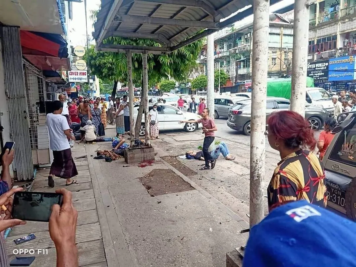 Four injured people can lying on the pavement after an explosion at a bus stop in downtown Yangon in Burma on May 31, 2022. (Burma Military True News Information Team via AP)