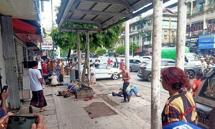 Four injured people can lying on the pavement after an explosion at a bus stop in downtown Yangon in Burma on May 31, 2022. (Burma Military True News Information Team via AP)