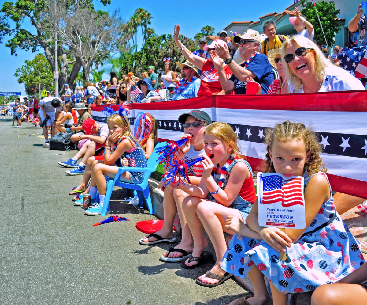 Families watch the Huntington Beach Independence Day Parade in Huntington Beach, Calif., on July 4, 2014. (Eric Zhang/The Epoch Times)