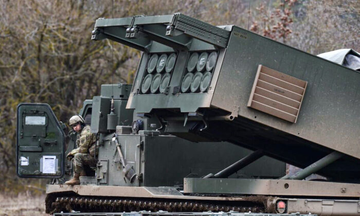 A U.S. soldier sits at a Multiple Launch Rocket System (MLRS) during the demonstration of the reload procedures after an artillery live fire event at a military training area in Grafenwoehr, southern Germany, on March 4, 2020. (Christof Stache/AFP via Getty Images)