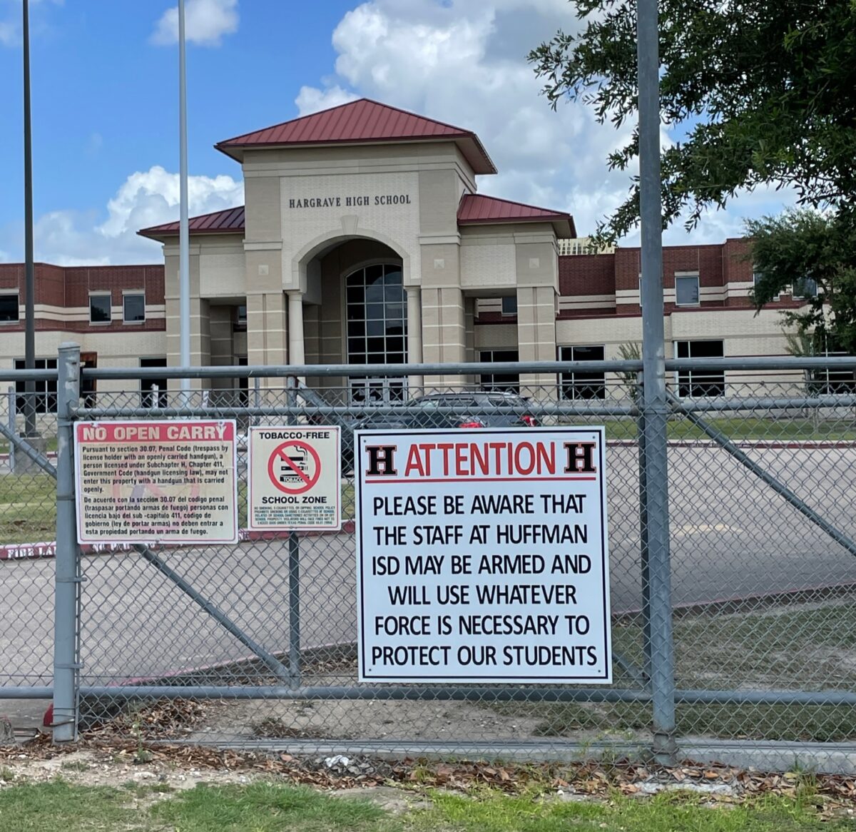 Signage at Hargrave High School in the Huffman Independent School District in Texas warns those who may enter school property with ill intent that open carry is prohibited and that staff may be armed with concealed weapons and will use whatever force is necessary to protect the students in their charge. 