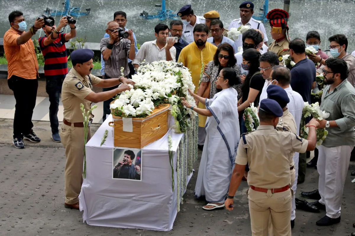 Mamata Banerjee, Chief Minister of the eastern state of West Bengal, places a wreath on the coffin containing the body of Indian singer Krishnakumar Kunnath, better known as KK, before a gun salute in Kolkata, India, on June 1, 2022. (Rupak De Chowdhuri/Reuters)