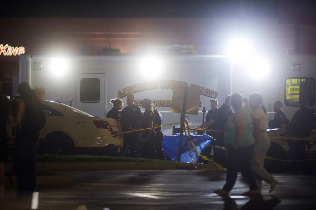 Emergency personnel gather at the scene of a crash that killed two women and injured 20 bystanders watching classic cars cruise in Lincoln, Neb., early on May 30, 2022. (Kenneth Ferriera/Lincoln Journal Star via AP)