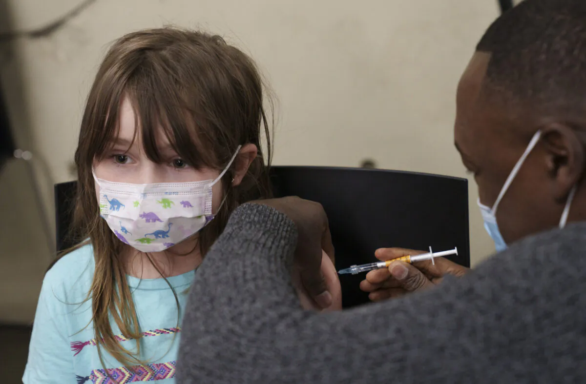 A young child receives a COVID-19 vaccine during the second day of vaccination for children aged five- to 11-years old in Montreal, on Nov. 25, 2021. (The Canadian Press/Paul Chiasson)