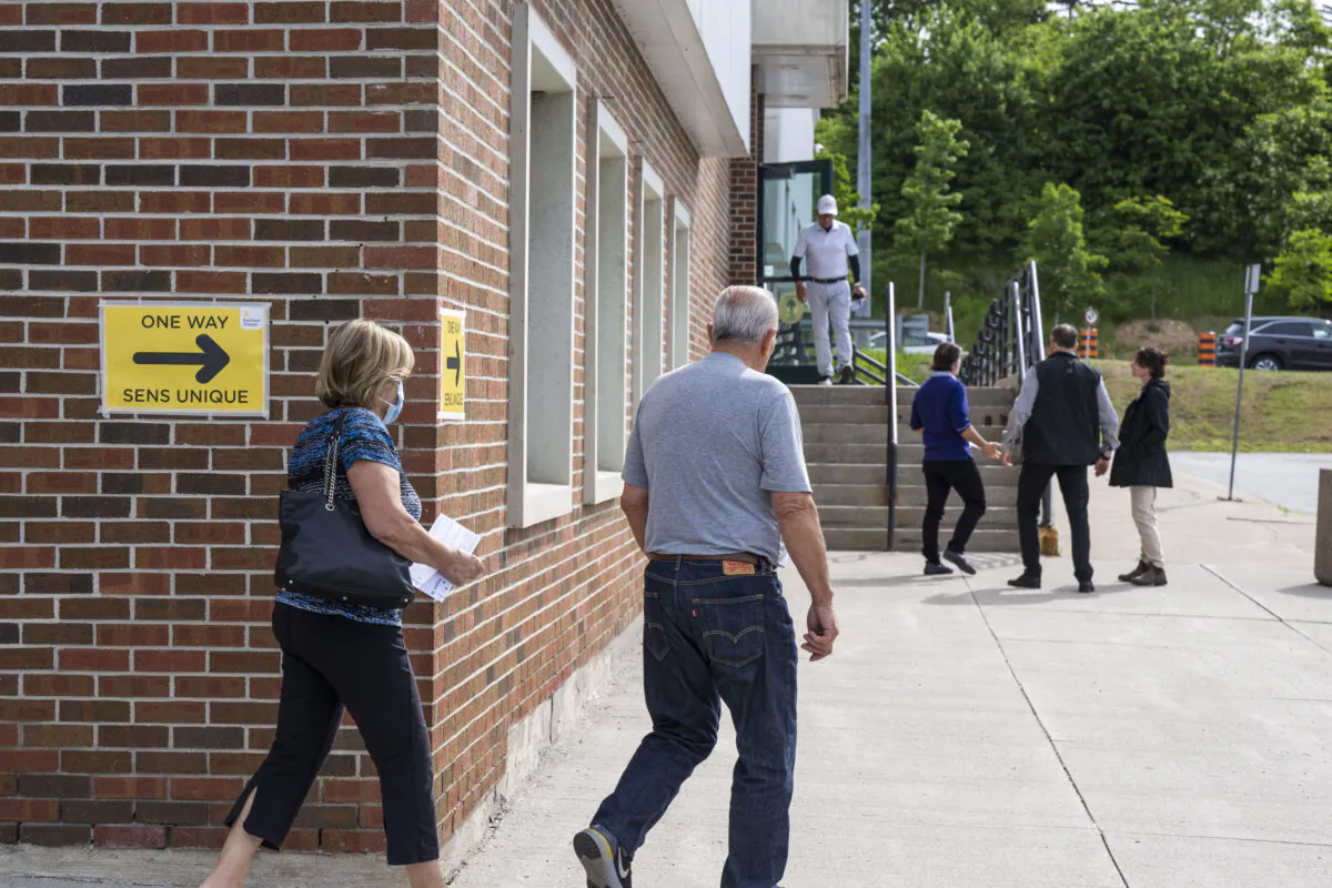 Voters walk to the cast their vote for the Ontario Provincial election at the Vaughan-Woodbridge polling station in Woodbridge, Ont., June 2, 2022. (The Canadian Press/Aaron Vincent Elkaim)