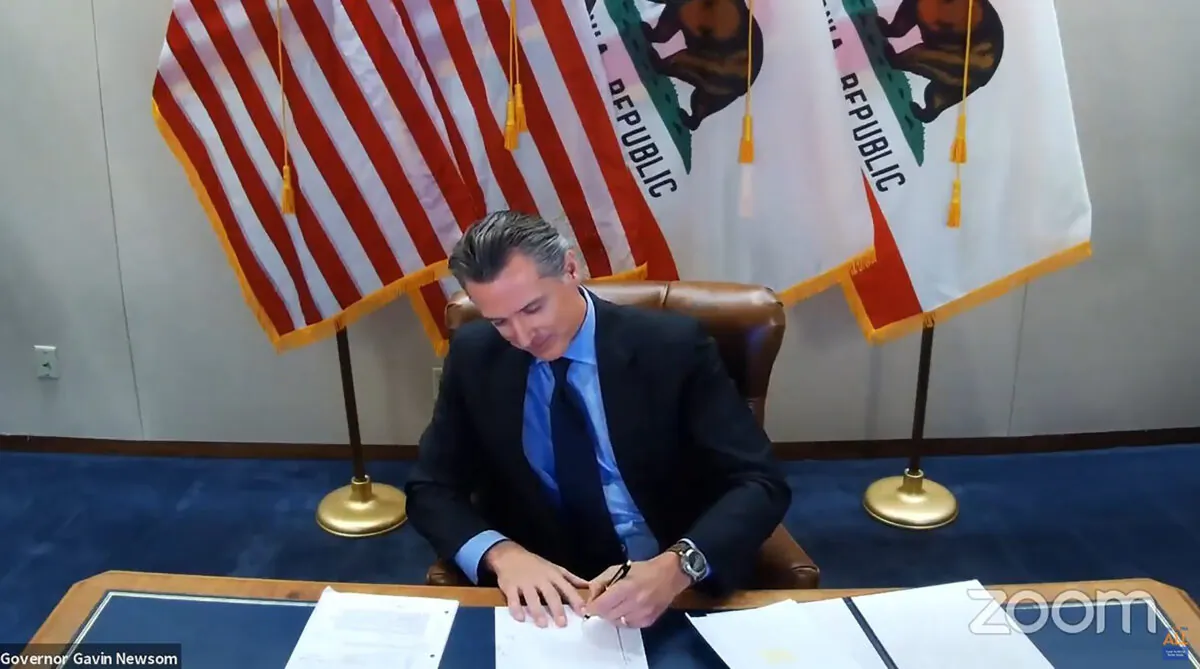 California Gov. Gavin Newsom signs into law a bill that establishes a task force to come up with recommendations on how to give reparations to Black Americans in Sacramento, Calif. on Sept. 30, 2020. (Office of the Governor via AP)