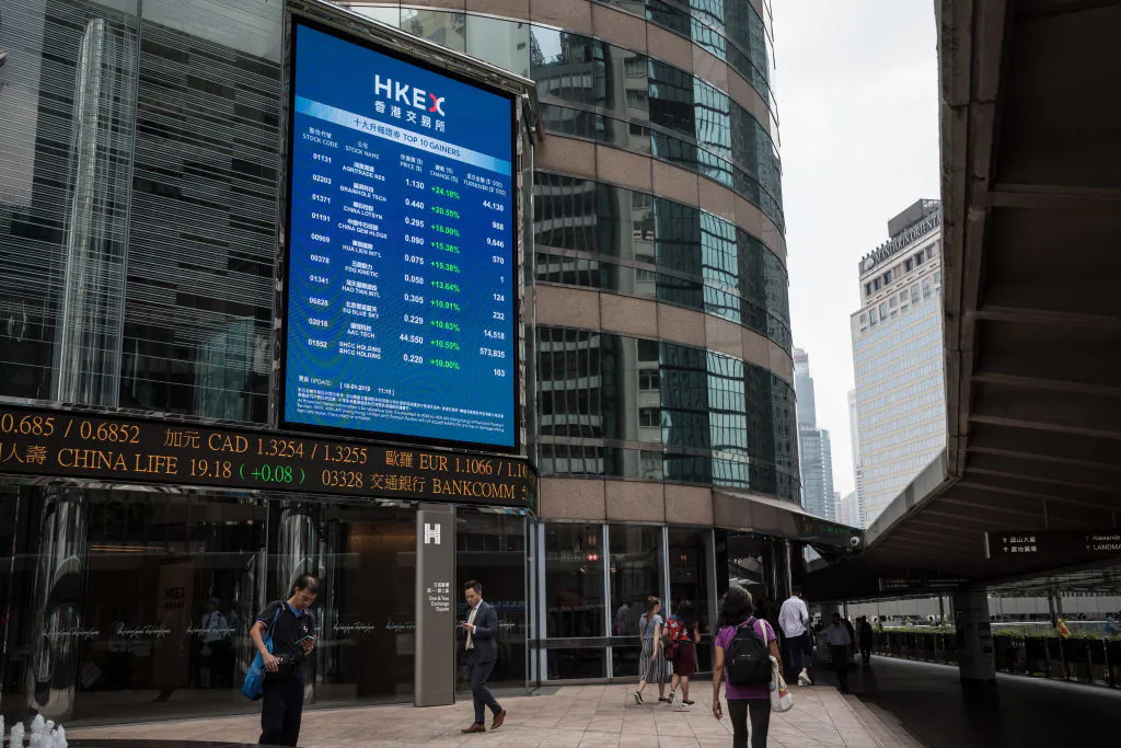 People walk past stock boards at the HKEX offices on Sept. 18, 2019 in Hong Kong, China. (Chris McGrath/Getty Images)