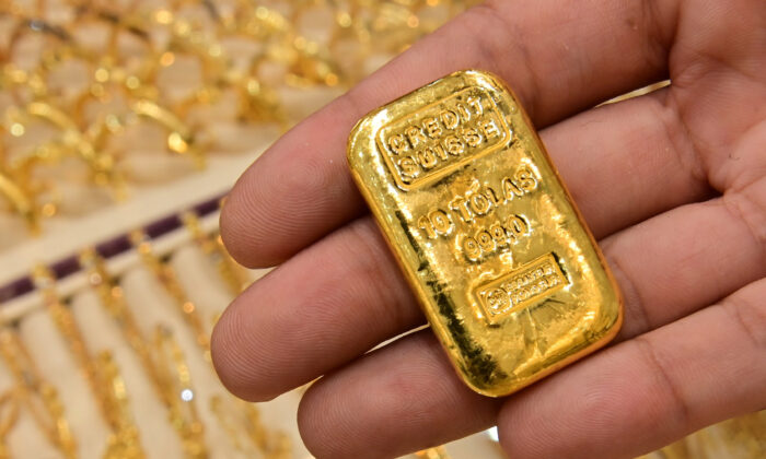 A merchant displays a gold bar at his shop in Dubai Gold Souk in the Gulf emirate on July 29, 2020. (Giuseppe Cacace/AFP via Getty Images)