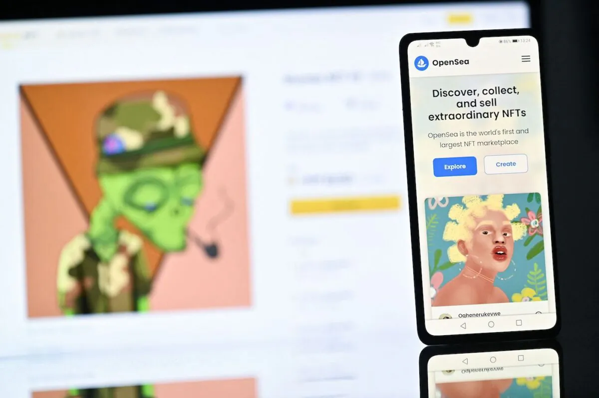 A NFT (Non-Fungible Token) created by Nigerian digital artist FreddieJacobArt as featured on the OpenSea NFT marketplace, displayed on a phone, and Binance NFT marketplace displayed on a computer screen. (Justin Tallis/AFP via Getty Images)