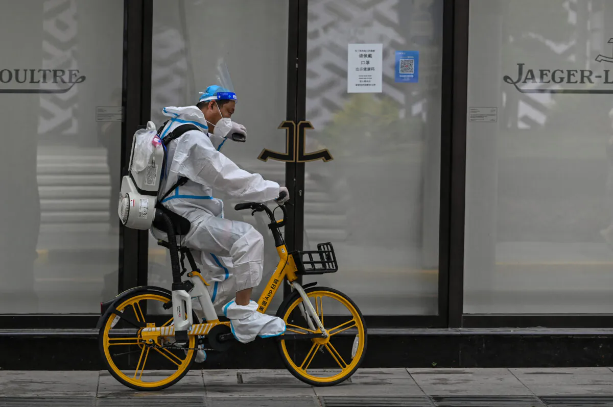 A worker rides a bicycle on a street in the Jing'an district of Shanghai on June 1, 2022. (Hector Retamal /AFP via Getty Images)
