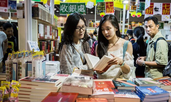 Visitors browse through books on display at the International Book Fair in Hong Kong on July 20, 2017. (Isaac Lawrence/AFP via Getty Images)