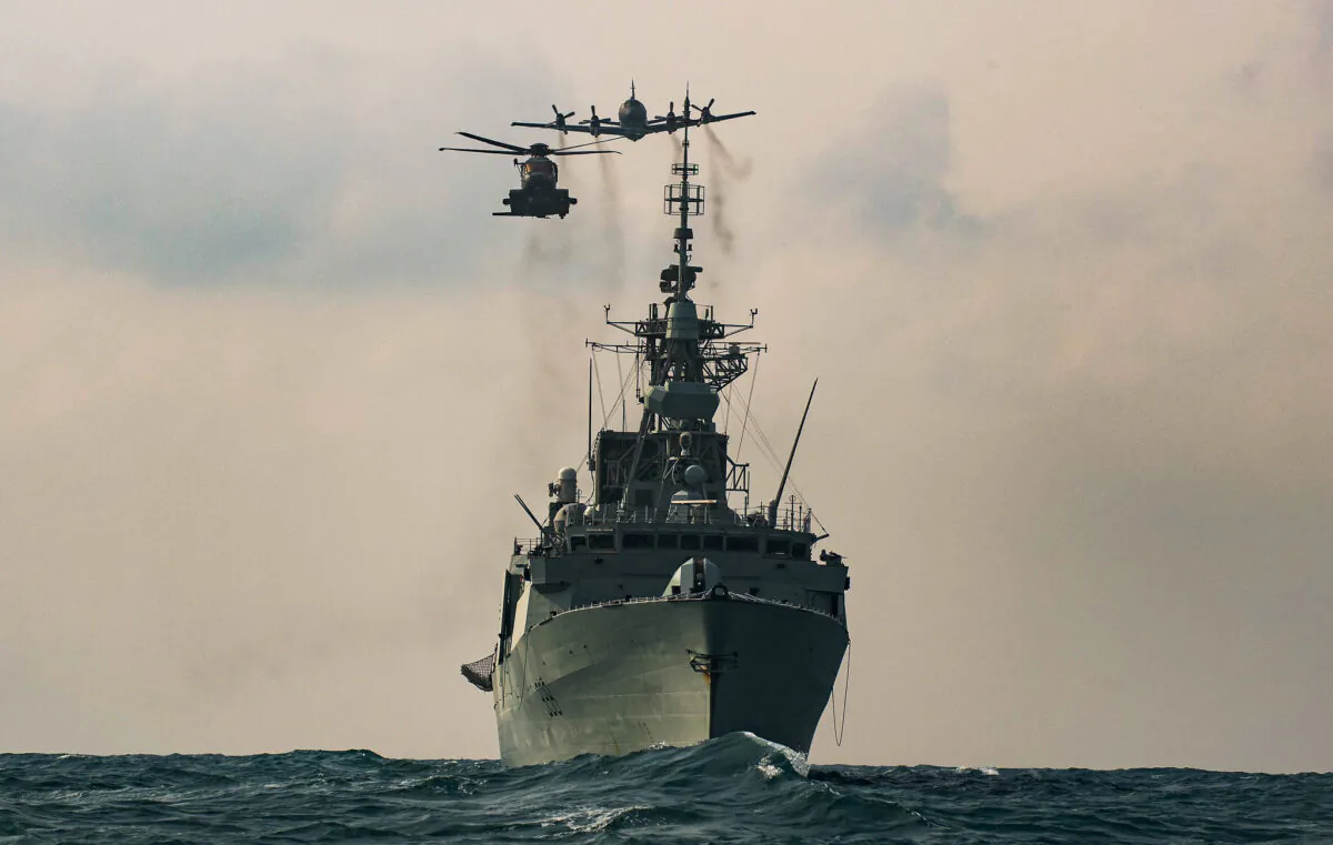 A CH-148 Cyclone helicopter and a CP-140 Aurora maritime patrol aircraft fly over HMCS WINNIPEG as part of a photo exercise in the Asia-Pacific Region during Operation NEON, November 15, 2020.
(Sailor 1st Class Valerie LeClair, MARPAC Imaging Services/CAF Combat Camera via Flickr)