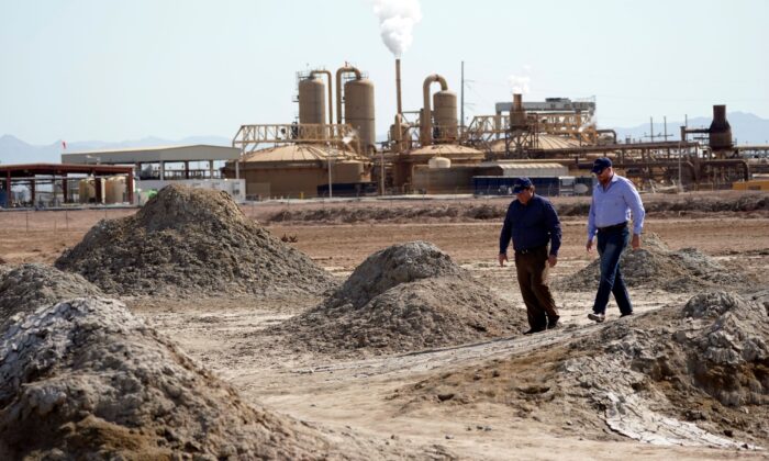 Rod Colwell, CEO of Controlled Thermal Resources (R), and Tracy Sizemore, the company's global director of battery materials, walk along geothermal mud pots near the shore of the Salton Sea, where the company is mining for lithium, in Niland, Calif., on July 15, 2021. (Marcio Jose Sanchez/AP Photo)
