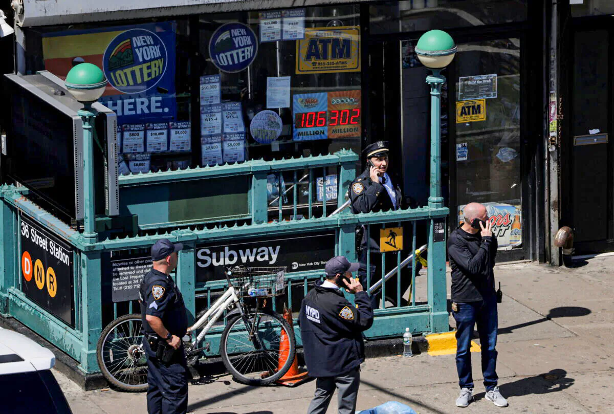 Law enforcement officers stand outside a subway station, the scene of a shooting, in the Brooklyn borough of New York on April 12, 2022. (Andrew Kelly/Reuters)