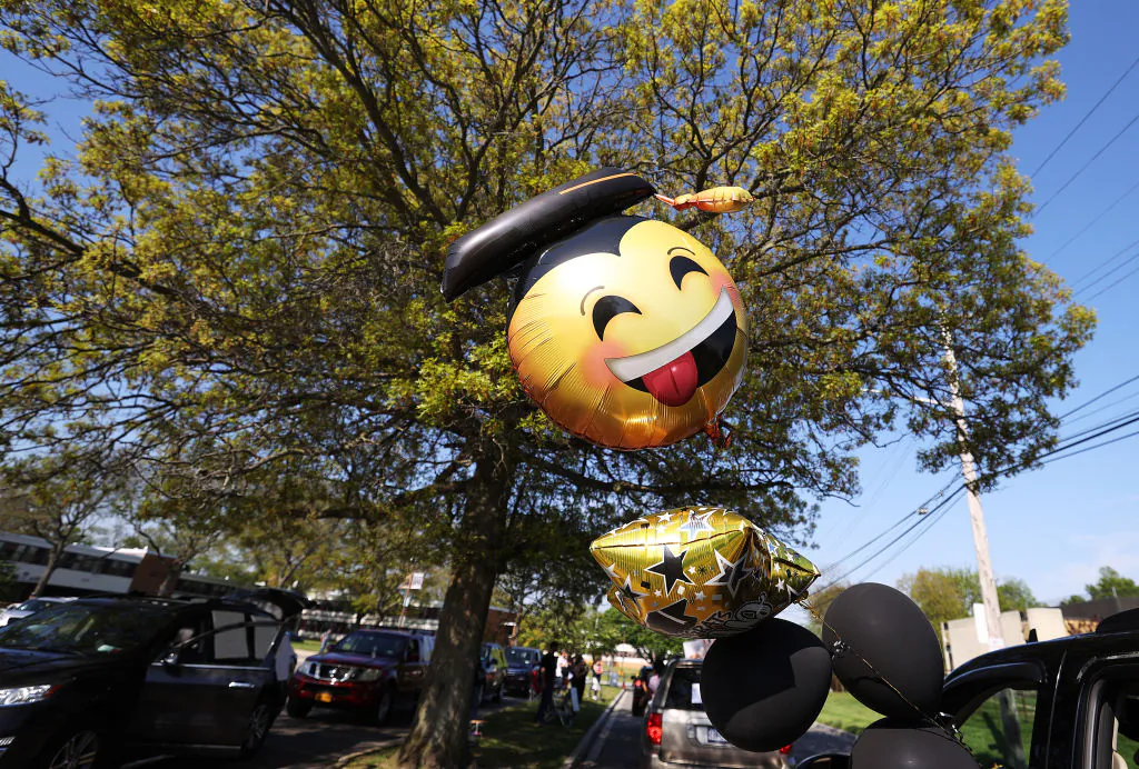 A balloon is displayed out of a car as graduating Seniors from Wantagh High School drive by the front of the school in a Class of 2020 Parade on May 15, 2020, in Wantagh, New York. (Al Bello/Getty Images)