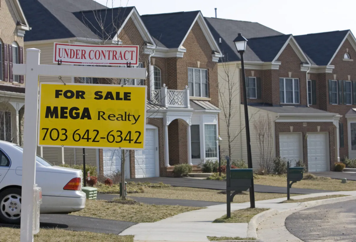 A real estate "For Sale" sign hangs on the front of new townhomes in Centerville, Virginia on March 14, 2007. (Paul J. Richards/AFP via Getty Images)