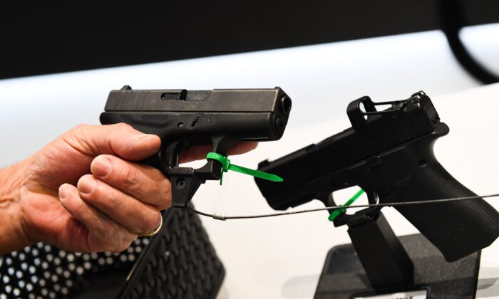 An attendee holds a Glock Ges.m.b.H. pistol during the National Rifle Association (NRA) Annual Meeting at the George R. Brown Convention Center, in Houston, Texas, on May 28, 2022. (Patrick T. Fallon/AFP/Getty Images)