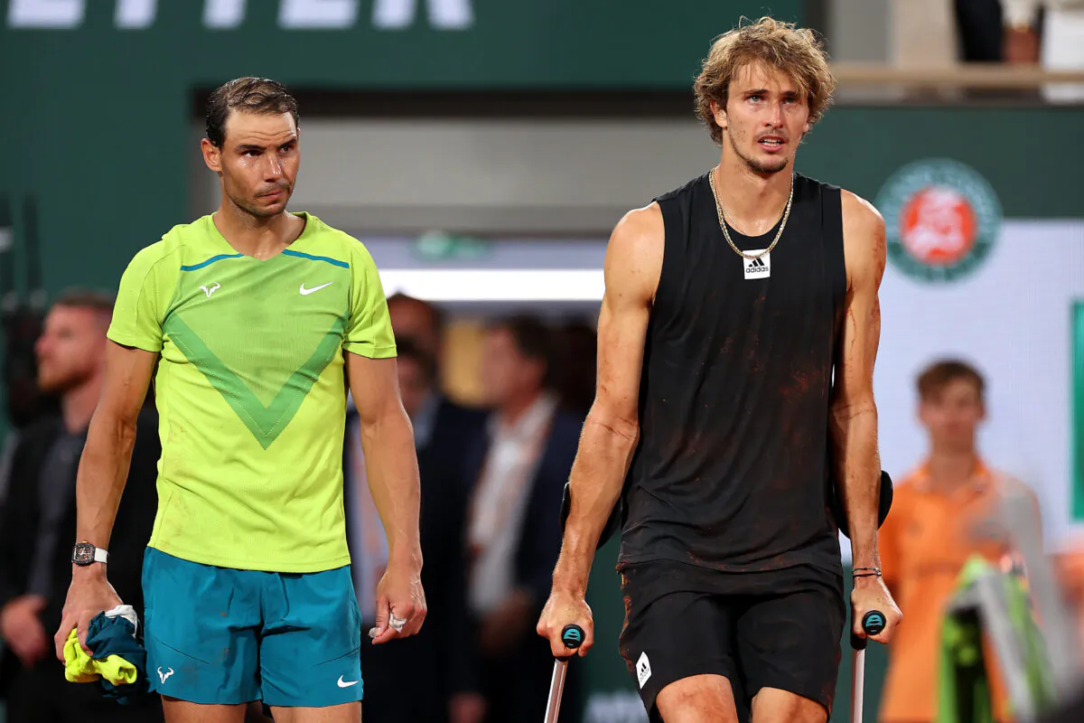 Alexander Zverev (R) of Germany walks back out to the court on crutches with Rafael Nadal of Spain following an injury against Rafael Nadal of Spain during the Men's Singles Semi Final match on Day 13 of The 2022 French Open at Roland Garros in Paris on June 3, 2022. (Ryan Pierse/Getty Images)