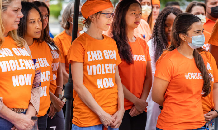 Nurses and doctors against gun violence stand together wearing orange at UCI Medical Center in Orange, Calif., on June 3, 2022. (John Fredricks/The Epoch Times)