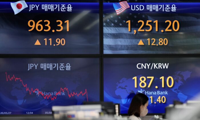 A currency trader walks by the screens showing the foreign exchange rates at a foreign exchange dealing room in Seoul, South Korea, on June 3, 2022. (Lee Jin-man/AP Photo)