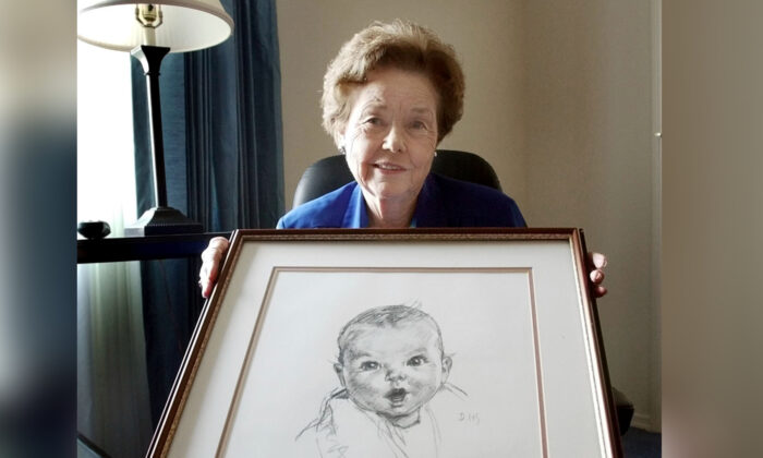 Ann Taylor Cook, poses at her home in Tampa, Fla., on Feb. 4, 2004, with a copy of her photo that is used on all Gerber baby food products. (Chris O'Meara/AP Photo)