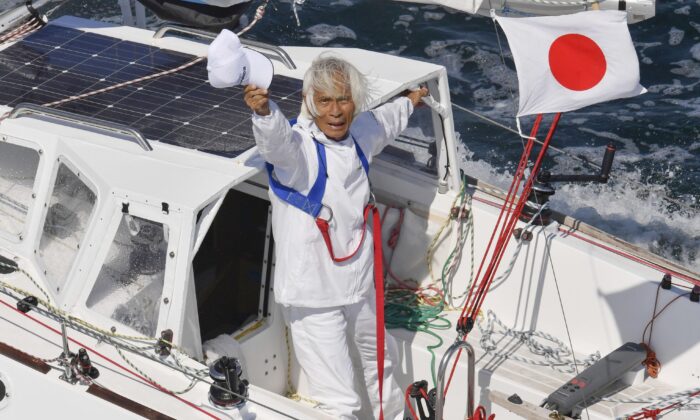 Japan's Kenichi Horie waves on his sailing boat after his trans-Pacific voyage, at Osaka Bay, western Japan, on June 4, 2022. (Kyodo News via AP)