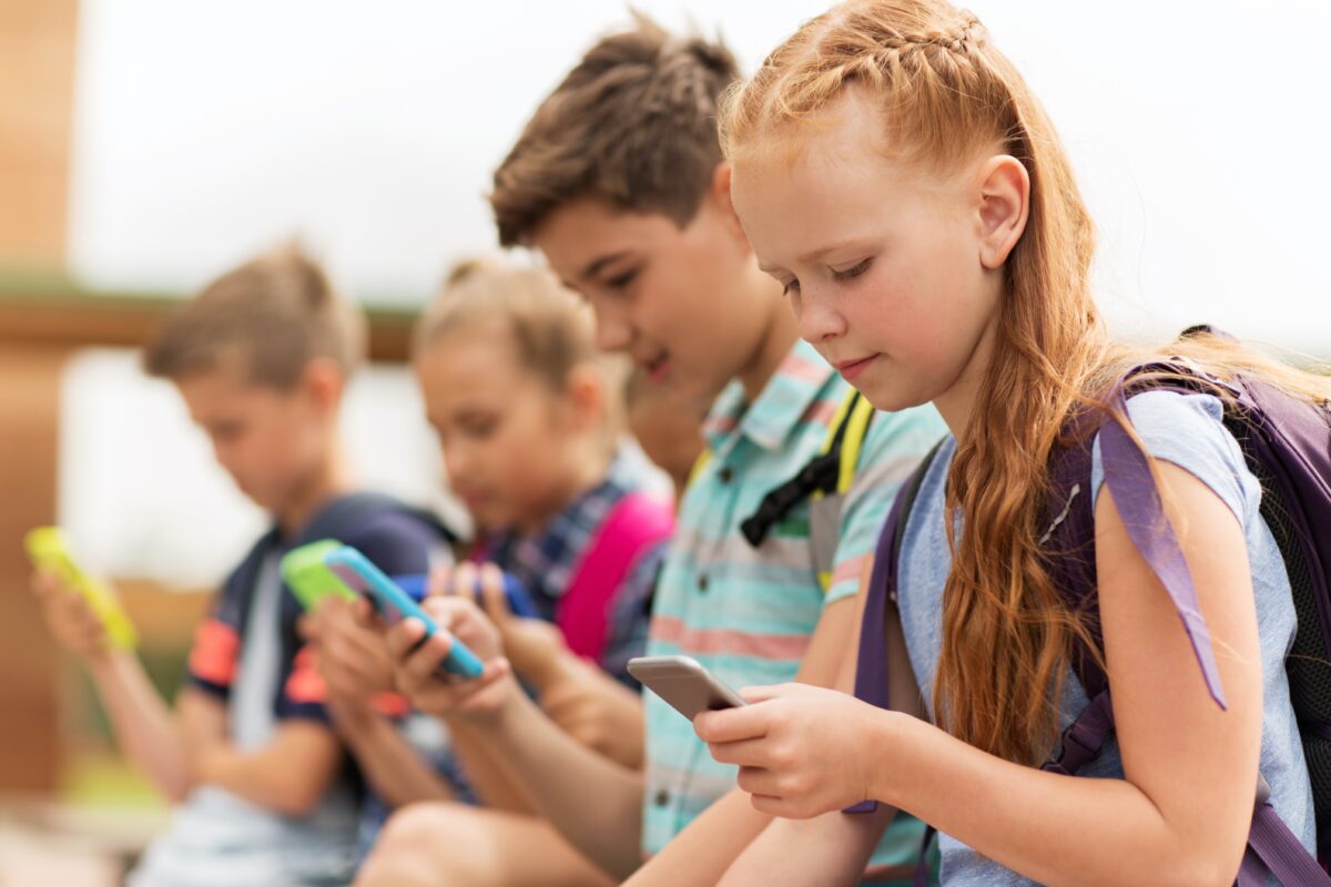 a group of kids using smartphones