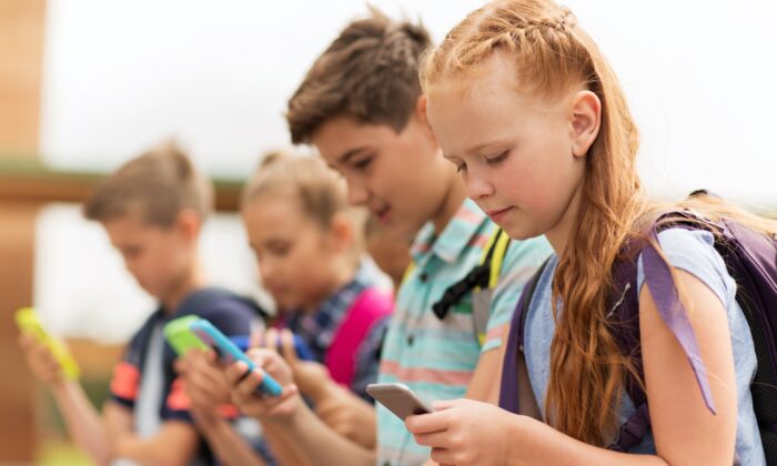 A group of kids using smartphones. (Syda Productions/Shutterstock)