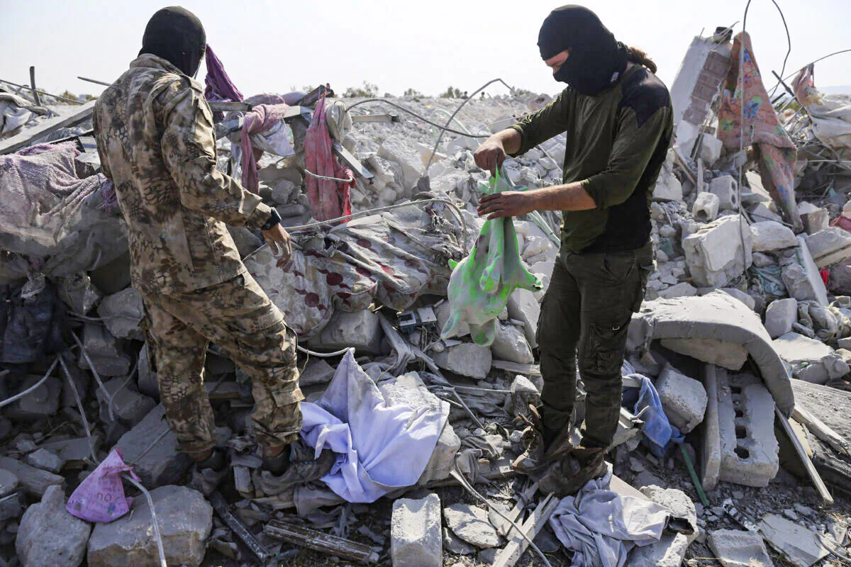 People look at a destroyed houses near the village of Barisha after an operation by the U.S. military which targeted Abu Bakr al-Baghdadi, the shadowy leader of ISIS, in Idlib province, Syria, on Oct. 27, 2019. (Ghaith Alsayed/AP Photo)