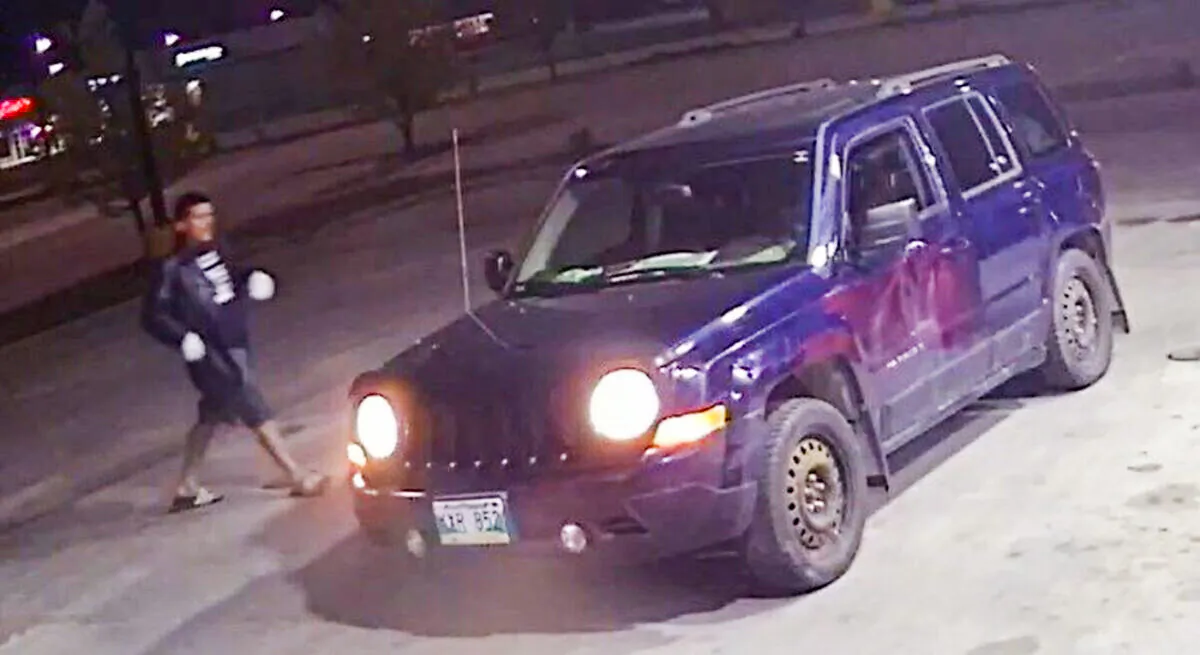 A man is seen approaching a blue 2012 Jeep Patriot in an undated police handout photo. Police say a woman with dementia who was allegedly abducted while the Jeep was parked at a gas station has been found safe. (The Canadian Press/HO-Winnipeg Police Service)