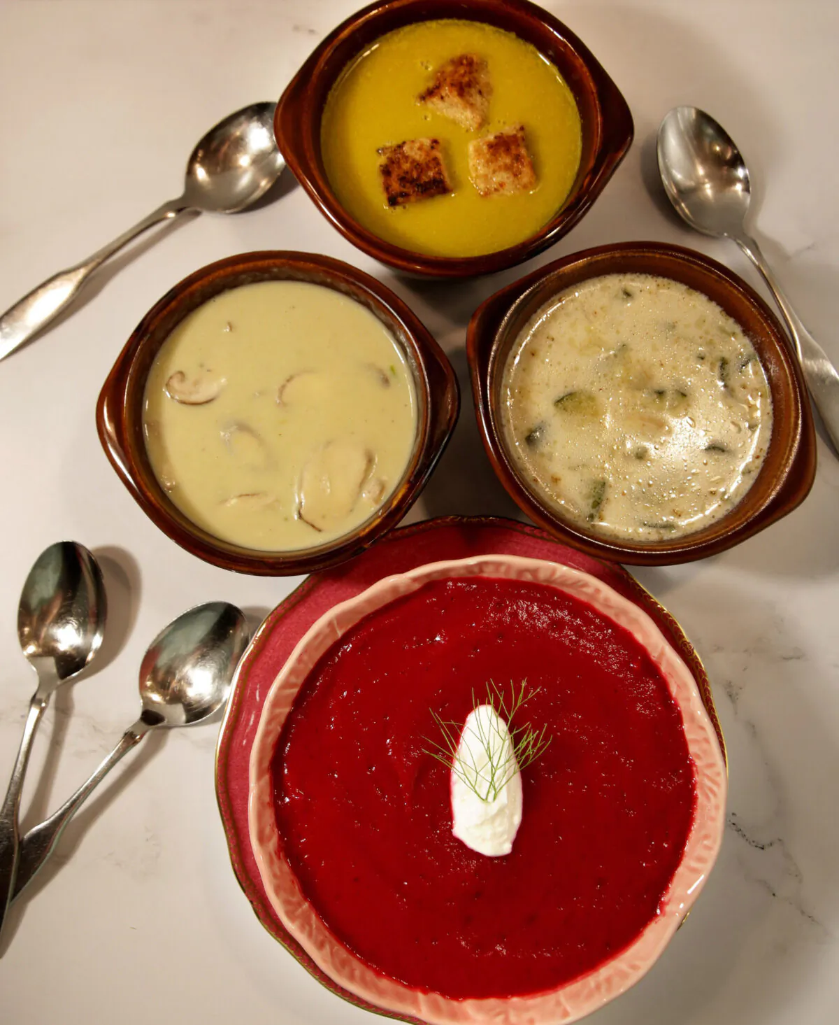 A selection of summer soups. At top: Sweet Pea soup, middle row: Asparagus and Shiitake Mushroom soup, left, and Cream of Zucchini and Almond soup, bottom: Beet-Fennel-Ginger soup. (Hillary Levin/St. Louis Post Dispatch/TNS)